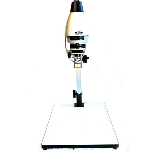 A black and white photographic enlarger with a light grey head mounted on an adjustable column above a flat base.
