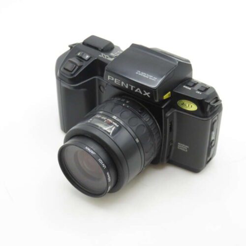 A Pentax film camera with a zoom lens, featuring a classic black body and various controls on top, viewed on a white background.