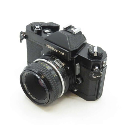 A vintage black Nikkormat SLR camera with a 50mm lens, featuring dials and controls on its top and a textured grip on the body.
