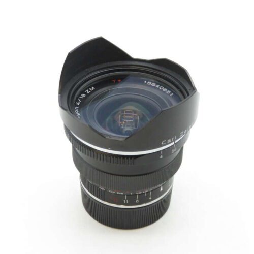 A Carl Zeiss Distagon T* 18mm f/4 lens with a wide-angle hood, featuring focus and aperture adjustment rings on a white background.