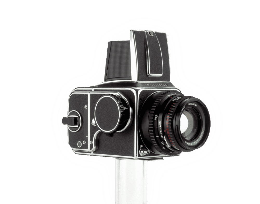 A vintage Hasselblad camera with a black body and silver detailing, featuring a large round lens and distinctive viewfinder, mounted on a white stand.