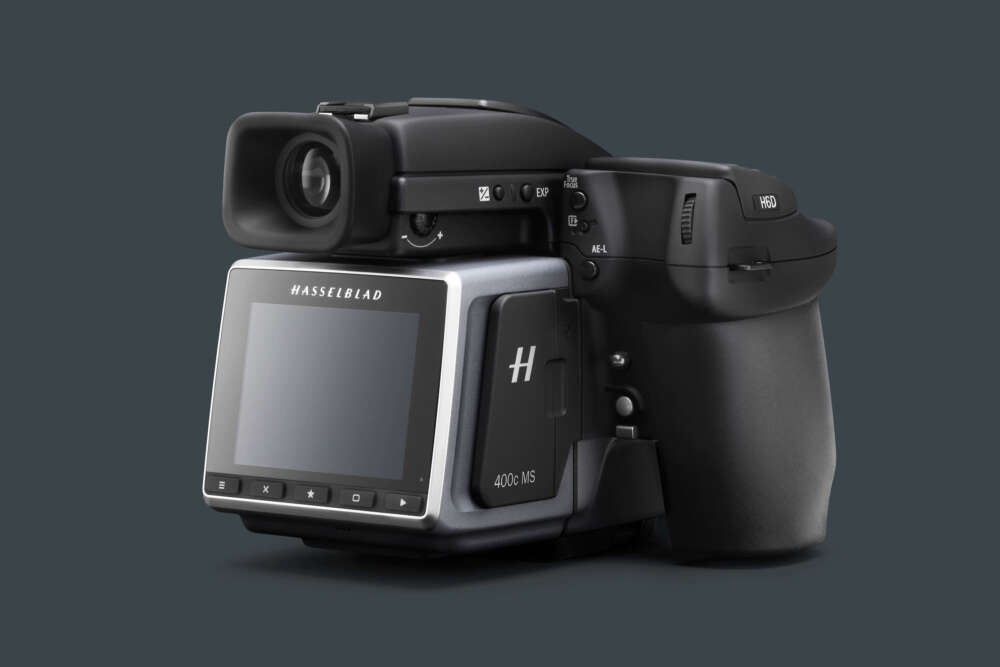 A Hasselblad H6D-400c medium format camera, featuring a digital back and ergonomic design, set against a dark background.