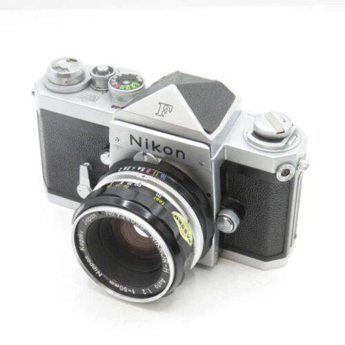 A vintage Nikon F camera with a 50mm f/2 lens, featuring a silver and black body with manual controls and a classic design.