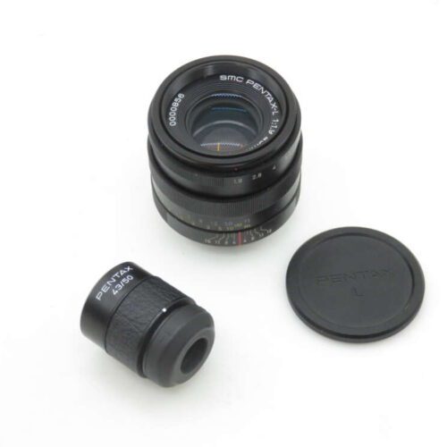 A Pentax SMC lens with lens cap and viewfinder attachment on a white background.