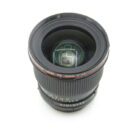 A Canon 24mm f/1.4 FD lens with a prominent front glass element and a textured focus ring, viewed from above on a white background.