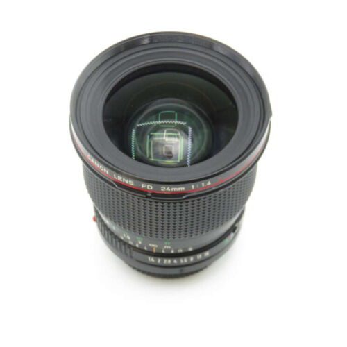 A Canon 24mm f/1.4 FD lens with a prominent front glass element and a textured focus ring, viewed from above on a white background.