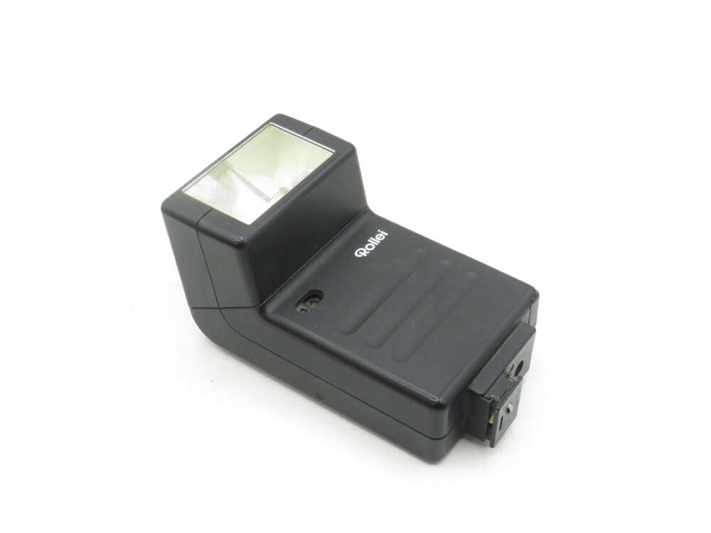 IMG_1697 A black Rollei camera flash unit with a rectangular flash head and a hot shoe mount, angled on a white background.