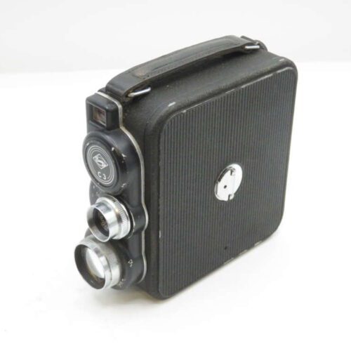 A vintage black movie camera with dual lenses and a textured finish, featuring a side handle and a compact design, placed on a white background.