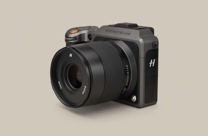 A Hasselblad X1D camera with a large lens, featuring a compact rectangular body and a prominent "H" logo on the lens cap, set against a plain background.