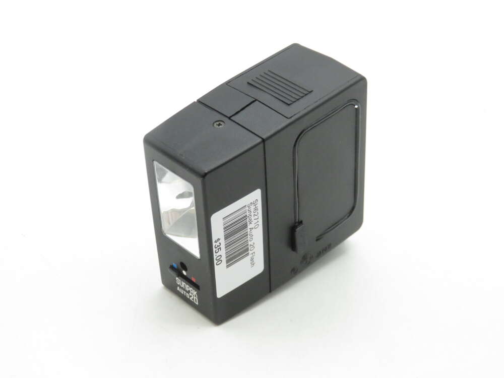 IMG_1739 A black rectangular Sunpak Auto 20 camera flash with a clear lens on one side and a label displaying the model and price attached to it.