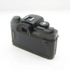 A black vintage camera viewed from the back, featuring a viewfinder, dials, and a textured grip, set against a white background.