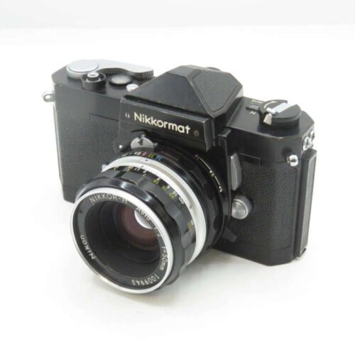 A vintage Nikkormat film camera with a Nikkor-H 50mm lens, featuring a black body and textured grip, displayed on a white background.