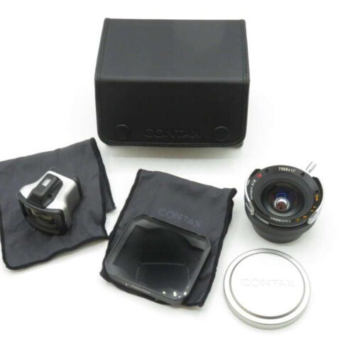 Contax camera lens kit including a black case, a lens with cap, a viewfinder, and two cloths, arranged on a white surface.