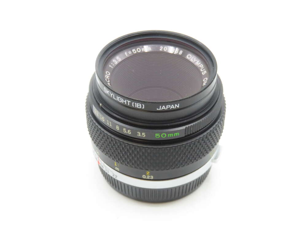IMG_1913 An Olympus OM-System Zuiko Auto-Macro 50mm lens with a Skylight filter attached, featuring f-stops from 3.5 to 16, and made in Japan. The lens has a textured focus ring and distance markings in meters and feet.