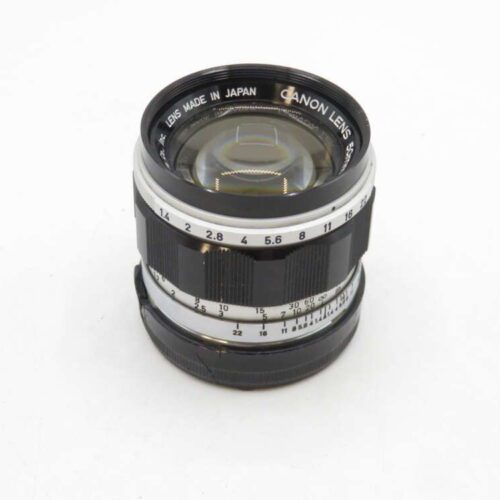 A Canon camera lens with a silver and black design, showing various aperture settings on its barrel, marked as "Made in Japan."