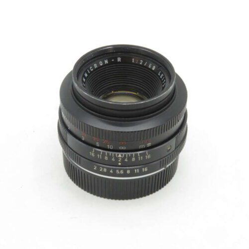 A Leica Summicron-R 50mm f/2 camera lens with focus and aperture rings visible against a plain white background.