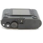 Top view of a black digital camera showing the LCD screen, control dials, and exposure settings.