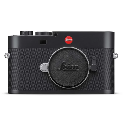 Front view of a Leica camera with a textured black body and a red logo, featuring a round lens cap with the Leica name on it.