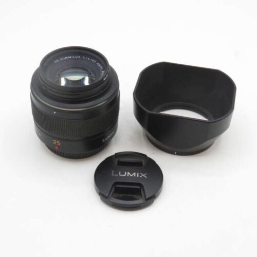 A Lumix 25mm camera lens with its lens hood and cap placed on a white surface.