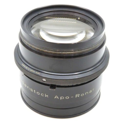 A large-format camera lens labeled "Rodenstock Apo-Ronar," with a black metal body and clear glass elements, made in Germany.