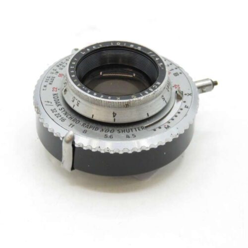 A Kodak Synchro-Rapid 800 shutter with a silver and black circular design, featuring a prominent lens opening and engraved numbers for aperture and speed settings.