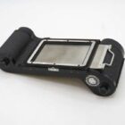 A vintage black film back accessory with a rectangular opening and metal details, used for medium format cameras.