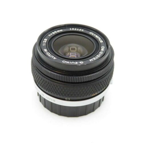 A black Olympus camera lens with "OM-SYSTEM G.ZUIKO AUTO-W" and "1:2.8 f=28mm" markings, showing its aperture and focal length details.