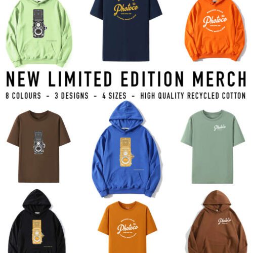 An advertisement showcasing limited edition merchandise from PhotoCo featuring various T-shirts and hoodies in different colours such as orange, blue, and green. Two designs are shown: one with a vintage camera graphic and another with the PhotoCo logo. The text highlights the availability in 8 colours, 3 designs, 4 sizes, and the use of high quality recycled cotton, designed by Luke Ormsby Art, exclusively available at PhotoCo.