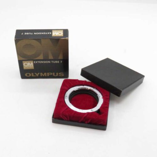 An Olympus extension tube 7, placed in a red-lined open box, with its packaging beside it.