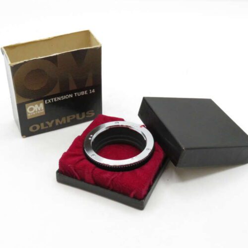 Olympus extension tube 14 displayed on a red velvet pad, next to its box and black lid.