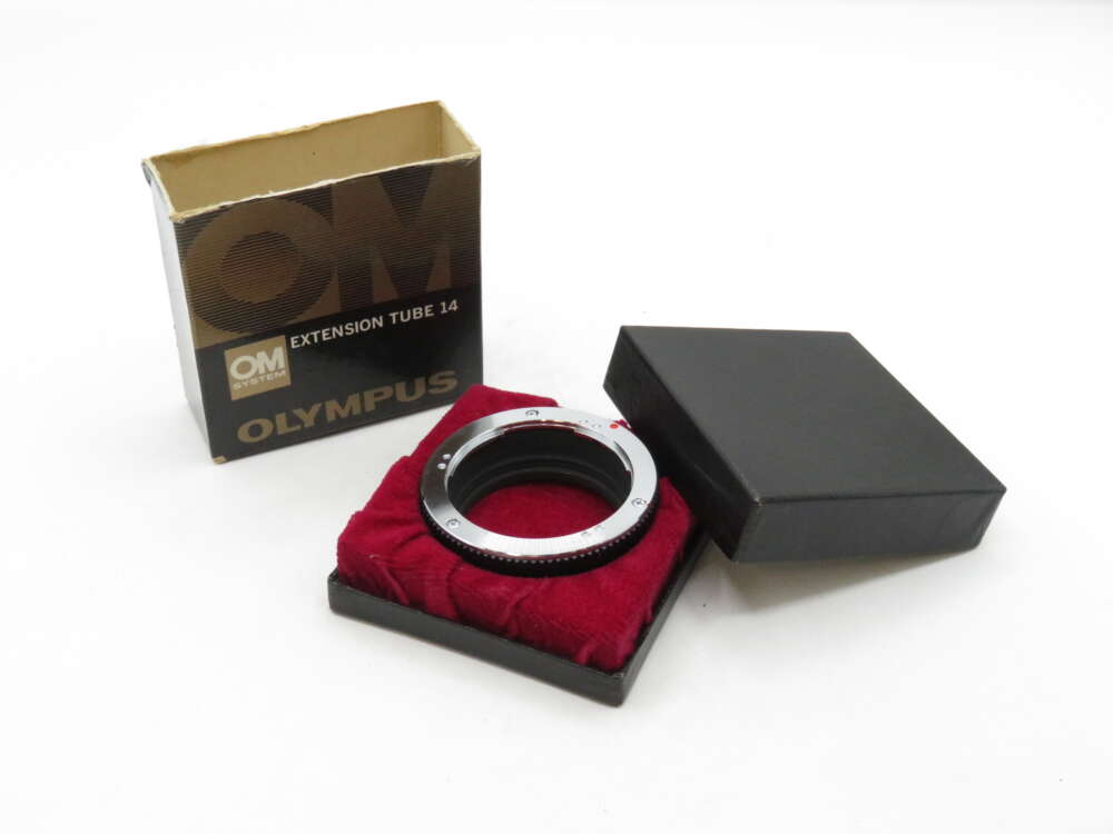 IMG_3065 Olympus extension tube 14 displayed on a red velvet pad, next to its box and black lid.