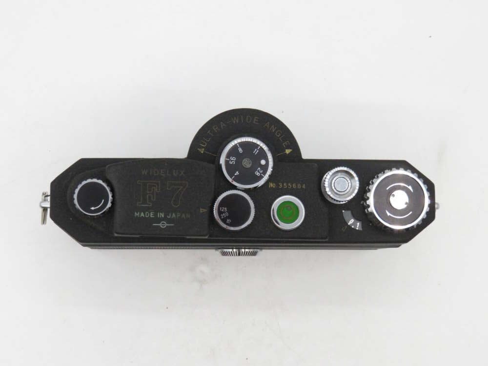 Top view of a vintage black camera with dials and settings for various controls.