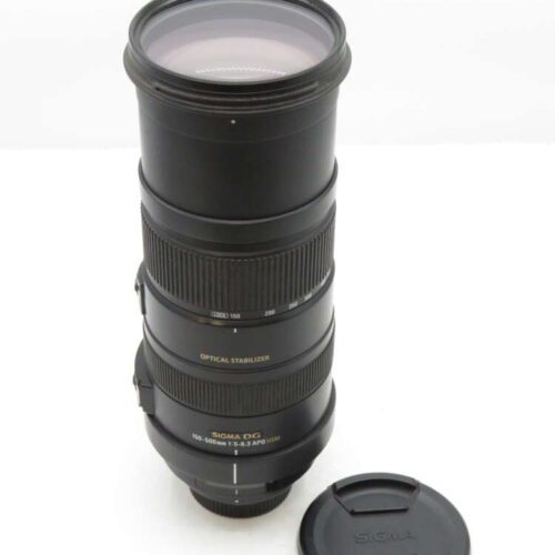 A Sigma 150-500mm lens with a black body, showing its zoom and focus rings, next to a detached lens cap.