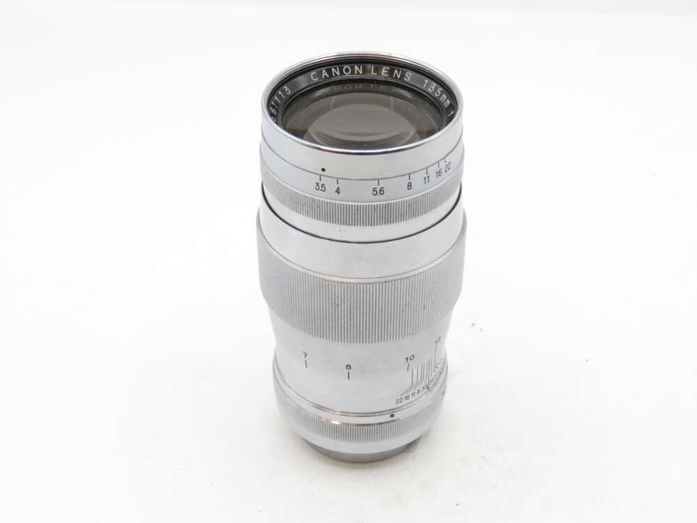 IMG_3124 A silver camera lens with a focus dial and aperture settings engraved on the side.