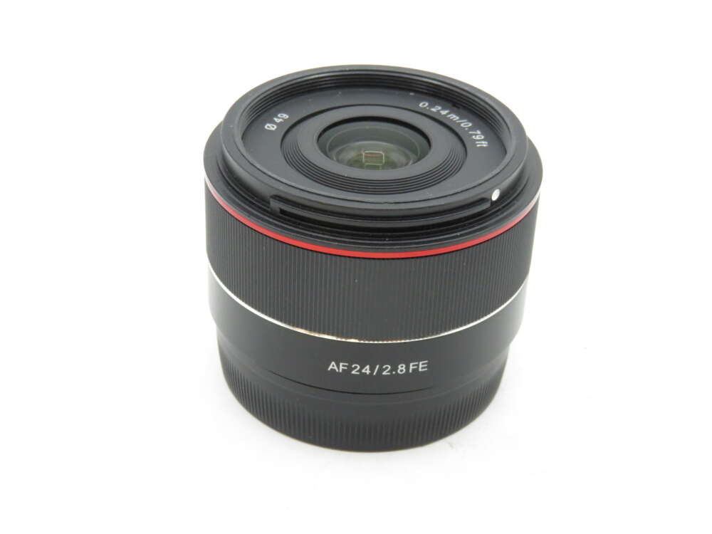 IMG_3132 A black camera lens with a red ring, labelled "AF 24/2.8 FE".