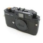 A black Bessa R3A rangefinder camera with a Voigtländer logo and a Leica lens cap.