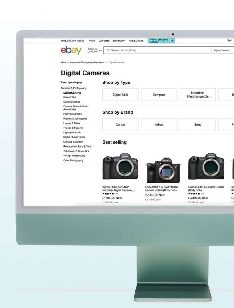 A computer screen displaying the eBay website page for digital cameras, with various models and prices listed.