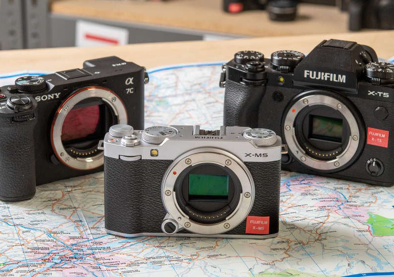Three interchangeable-lens cameras from Sony and Fujifilm are displayed on a map, with visible lens mounts.