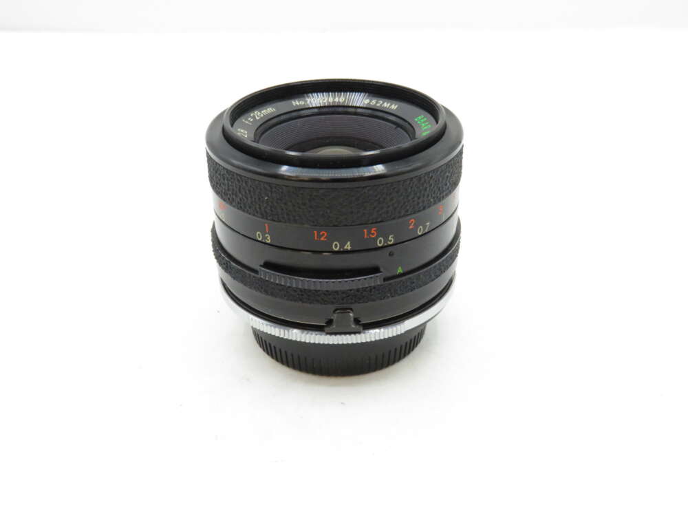 IMG_3290 A black camera lens with distance markings, featuring a textured focus ring and metal mount.