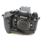 Black Nikon F4 film camera with a detachable lens cap and multiple control dials.