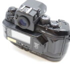 Black Nikon film camera with multiple dials and a digital display on the back.