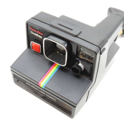 A vintage Polaroid Land Camera with a rainbow stripe and visible "Time-Zero OneStep" text.