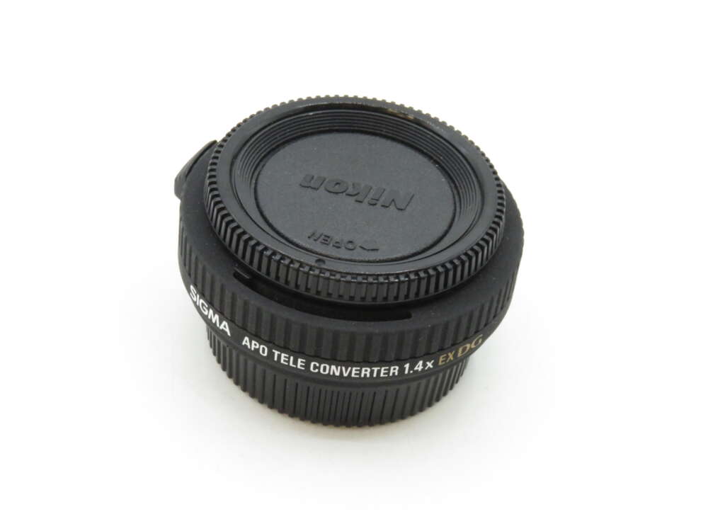 IMG_3465 A black Nikon APO teleconverter 1.4x lens with a protective cover.