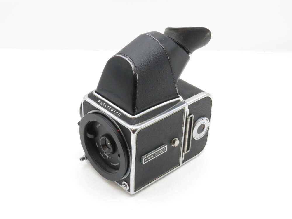 IMG_3470 A black and silver vintage Hasselblad film camera with a viewfinder attachment is shown against a white background.
