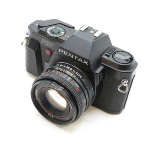 A black Pentax P30 film camera with a 50mm lens, featuring manual dials and a compact design.