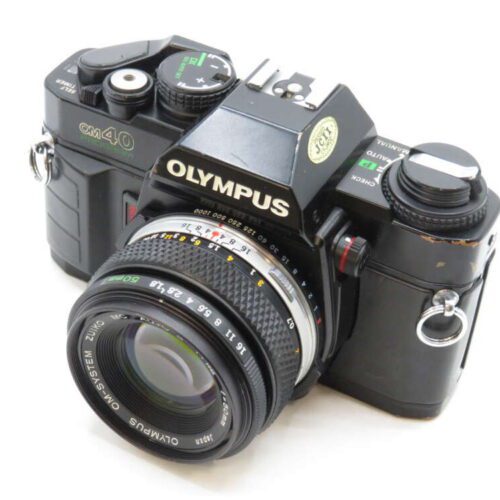 Black Olympus OM-40 film camera with a 50mm lens, showing dials and buttons on the top.