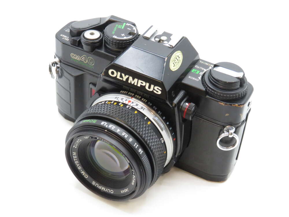 IMG_3542 Black Olympus OM-40 film camera with a 50mm lens, showing dials and buttons on the top.