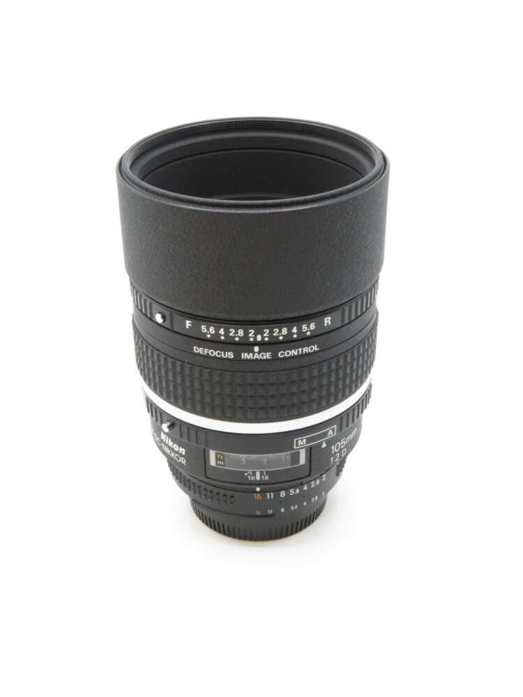 IMG_3567 A Nikon camera lens with defocus image control settings, featuring a textured grip and marked aperture values.