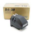 Nikon DA-30 AE Action Finder in front of its box, featuring a sleek black design with a visible control dial.