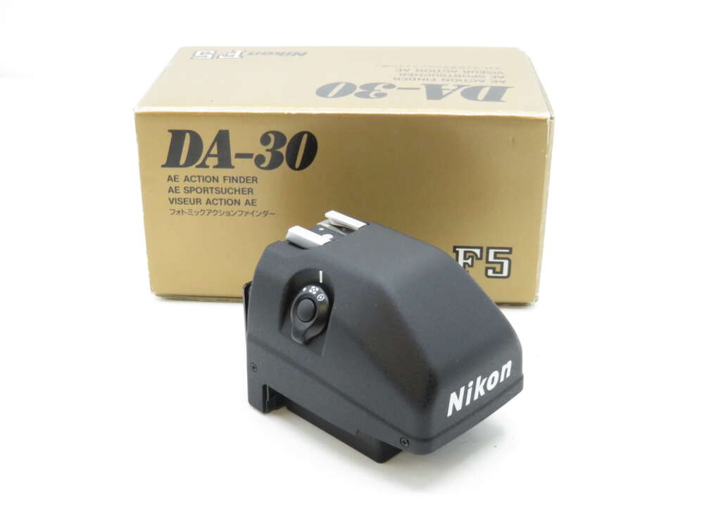 Nikon DA-30 AE Action Finder in front of its box, featuring a sleek black design with a visible control dial.